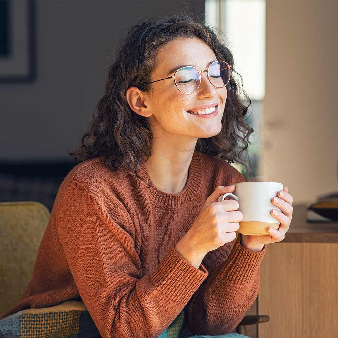 Woman smiling while holding a mug