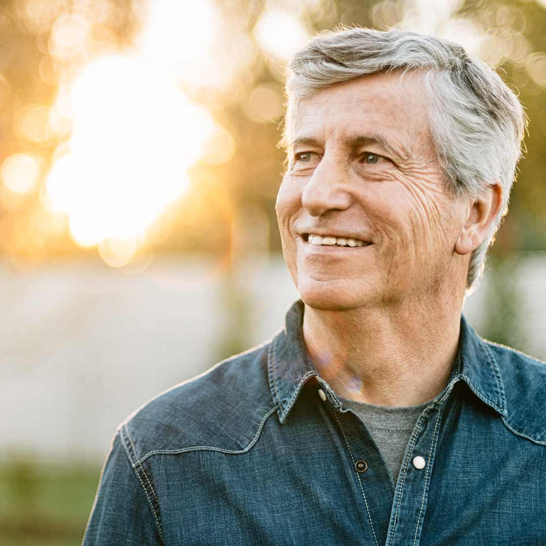 Older man smiling outside